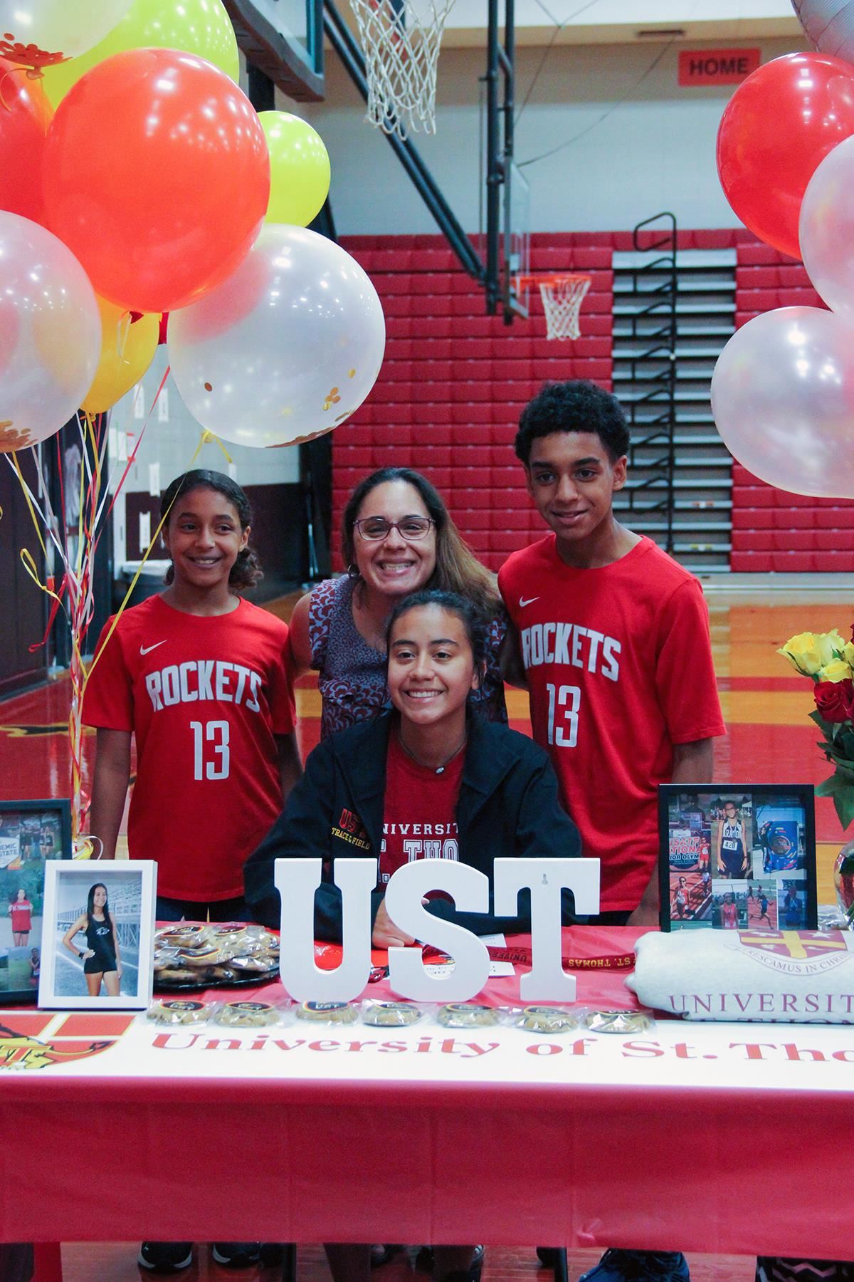 Langham Creek High School senior Hailey Perez, seated, poses with her family after signing her letter of intent.
